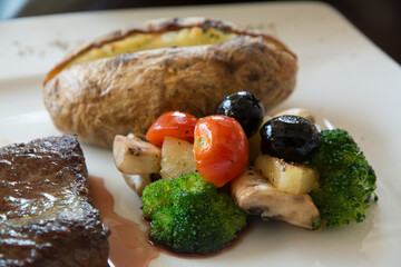 Whole potatoes, cherry tomatoes and broccoli served with steak
