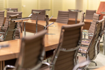 Konzept Kommunikation, Medien, Beratung, Presse, Politik, Unternehmen: Besprechungsraum oder Konferenzsaal mit Tischen, Stühlen und Mikrofonen, ein Mikrofon isoliert in der Mitte fokussiert