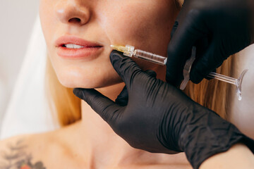 Doctor in gloves  giving woman injections in lips