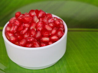 Fresh red color pomegranate kernels in a white bowl