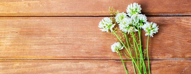 Wildflowers on a wooden background. Bouquet of clover. Place for text. Armful of flowering field plants.