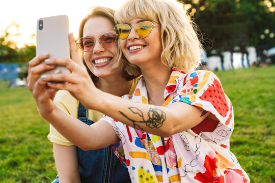 Image of cheerful two women taking selfie on mobile phone