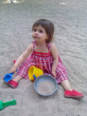Little baby girl playing in the sand