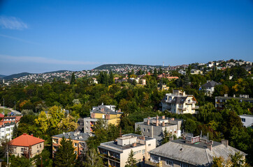 Obraz premium Aerial view of residential area buildings and forested hills of the Miskolc city in the north of Hungary at sunny summer day