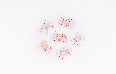 Step by step instruction how to make a Christmas tree decor. Macaroni in form of bow are painted with red gouache or acrylic. Part of the toys are ready. Decorative craft detail.