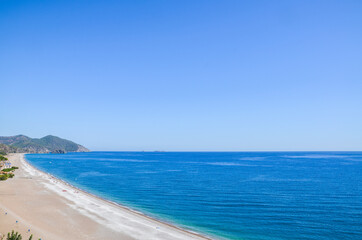 Fototapeta premium Summer mediterranean coastal landscape. View of Cirali Beach from ancient Olympos ruins, with mountains and pine trees in background Antalya Turkey.