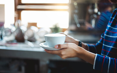 Young asian woman holding coffee cup to server for customer
