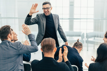 employees giving each other a high five during a work meeting