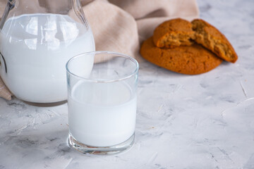 Milk in a glass cup and slices of oatmeal cookies on a linen napkin. The concept of home breakfast and healthy eating.