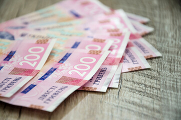 new banknotes with a face value of 200 hryvnias beautifully laid out on a wooden background. Ukrainian money. Business concept. Close-up.