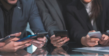 close up . employees with smartphones sitting at the Desk