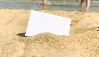 business card on the beach, empty white business card mockup in the sand against the background of the sea