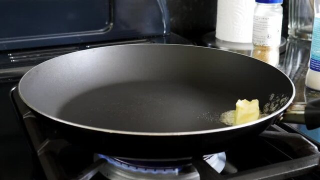 Close up view of butter melting as preparation to cook scrambled eggs