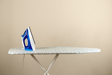 Homework. Blue electric iron on ironing board