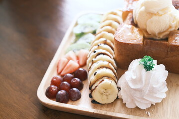 Delectable dessert with honey toast on top by ice cream and various fruits. close up, selective focus
