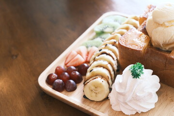 Delectable dessert with honey toast on top by ice cream and various fruits. close up, selective focus