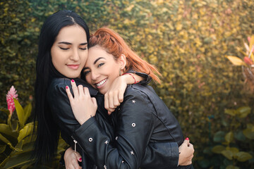 Fototapeta premium sisters and friends hugging outside the home