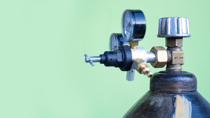 large metal gas cylinder with measuring instruments and gearboxes on a green background. copyspace...