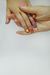Close up mother and daughter hands with multicolor nails, selected on white background.