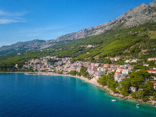 Fototapeta na wymiar Amazing aerial view of Makarska riviera, Dalmatia, Croatia. Daytime landscape of popular tourist resort on the Adriatic sea coast at the foot of the rocky Dinara mountains, outdoor travel background