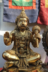Fototapeta na wymiar Bronze statuette - Hanuman sits in lotus pose with mace and blessing gesture.