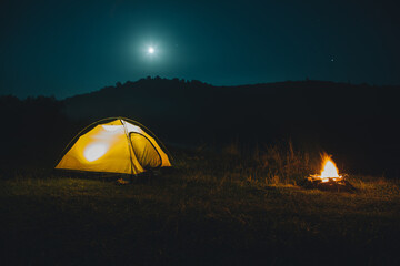 Fototapeta na wymiar long exposure bonfire with yellow tent on background