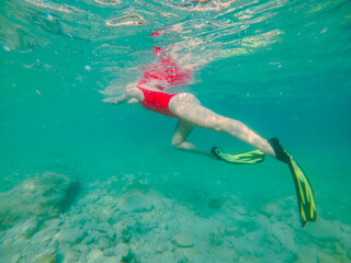 woman in red swimming suit underwater with snorkeling mask and flippers © phpetrunina14