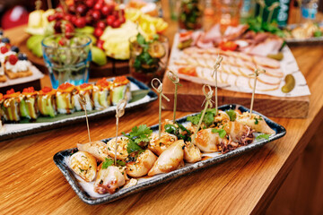 Stuffed squid cooked in Asian style with cilantro on banquet table, toned