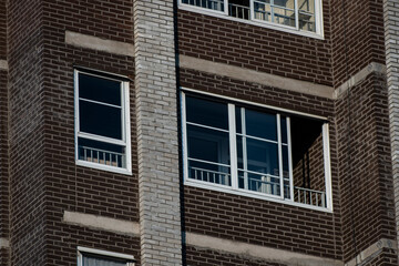 Window of a multi-storey building made of brown brick.