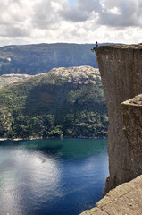 Girl sitting on the cliff of Preikestolen, Norway