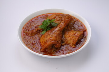 Chicken curry or masala,arranged in awhite bowl with white background