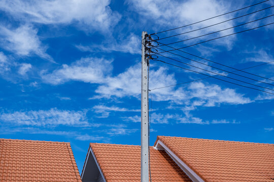 The roof of the house, electric pole and blue sky
