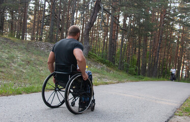 disabled sports man on a wheelchair in a park