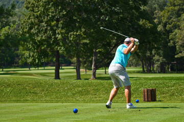Young Man Hitting an Iron off the Tee Box