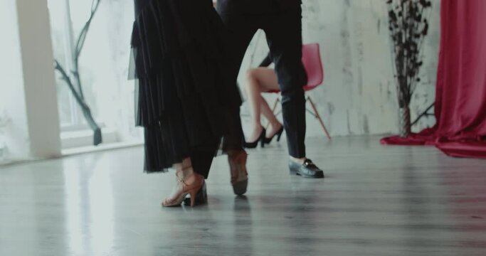 Low view of dancers' legs moving during dance at girls playing the violin