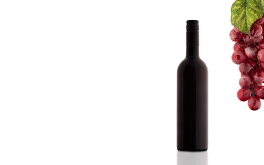 A bottle of wine and a bunch of grapes next to a copy space.