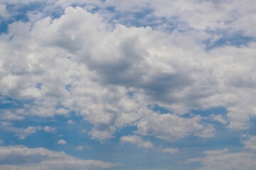 The fluffy white cloudscape in the blue sky.
