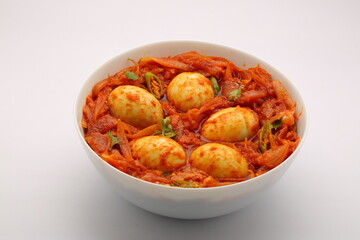 Egg roast or egg masala,spicy reddish dish arranged in a white bowl with white texture
