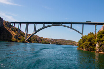 Metal bridge with arch through the sea gorge