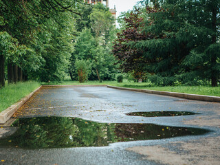 A girl in a yellow jacket and boots runs and jumps through puddles