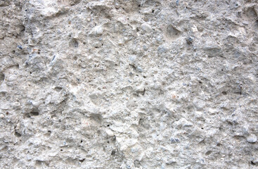 Textured concrete wall with cement and stones as background