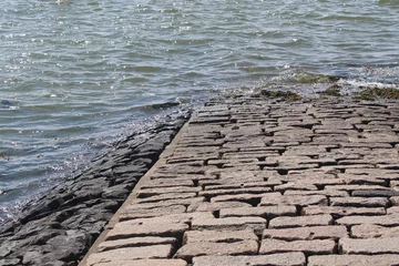 Gardinen Stone pier ending in the water. © Marije Kouyzer