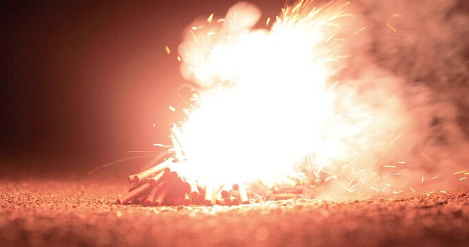 Low angle close up of lighting a pack of firecrackers and the explosion