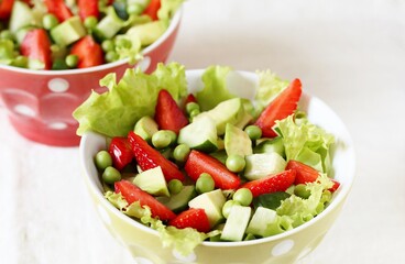 salad with strawberries, avocado, lettuce,  green peas. 