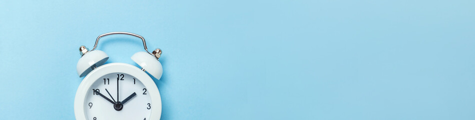 Simply minimal design ringing twin bell classic alarm clock Isolated on blue pastel background....