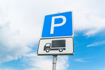 Lorry parking sign against the blue sky. Blue parking sign. Black truck on white plate. High quality photo