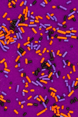 Purple, orange and black candy closeup on felt background