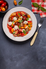 Traditional Caprese salad made of sliced fresh tomatoes, mozzarella cheese and basil
