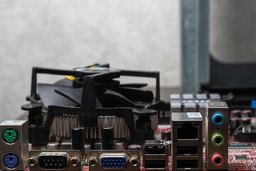 Fototapeta premium Side view of the motherboard with PCU cooler and ports. USB, VGA, DVI, Ethernet, sound ports. Close-up, background idea concept