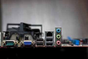 Close-up of port card on brown background. USB, VGA, Ethernet, DVI, sound ports